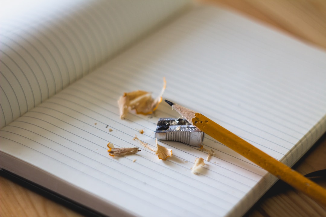 sharpened pencil and writing notebook