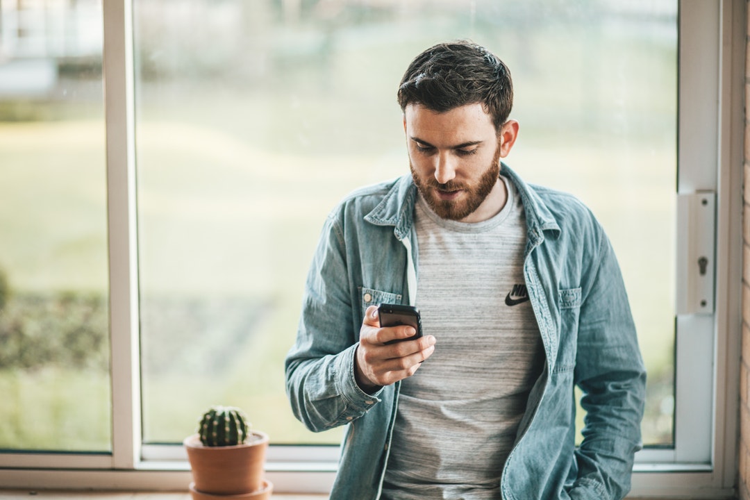 man looking at SMS on phone